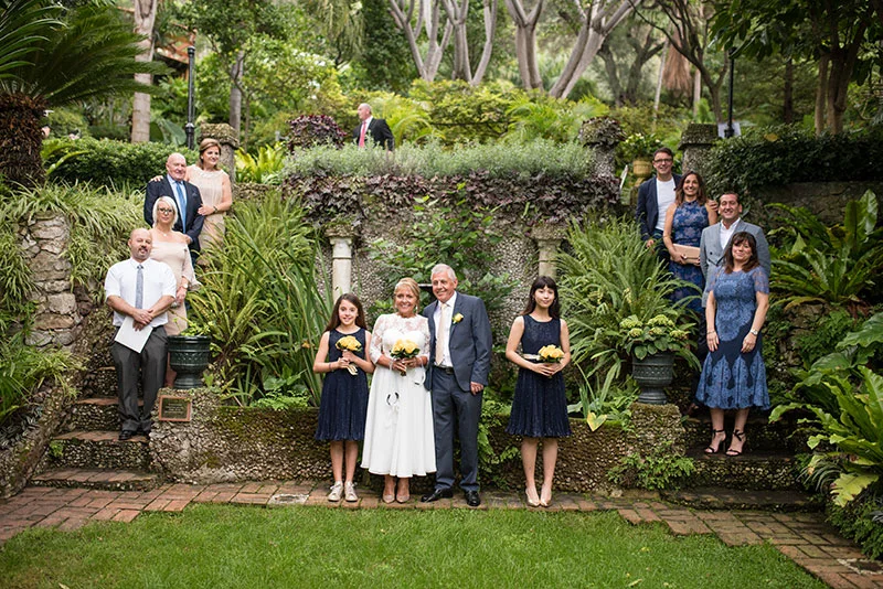 Wedding party and family gathered on the garden steps of botanical gardens in Gibraltar after an intimate ceremony