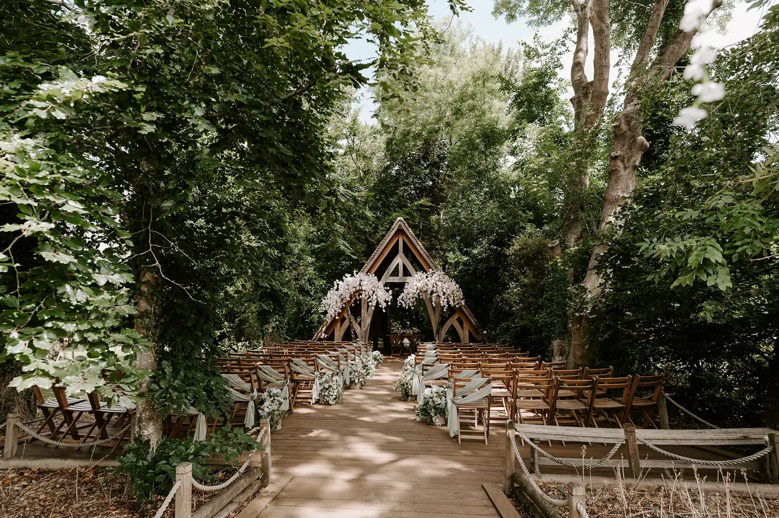 Woodland wedding ceremony beneath an oak-framed arch