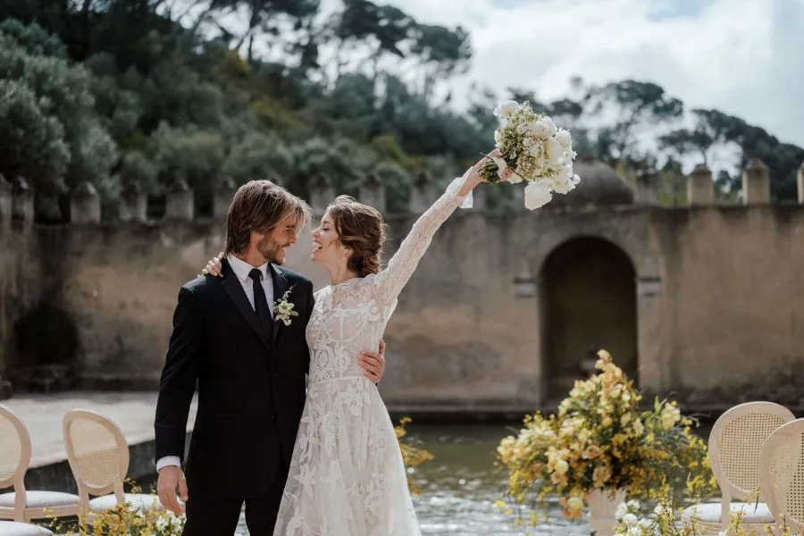 Bride and groom celebrating with a bouquet at a villa, an Ibiza wedding planned by Swish Soirées