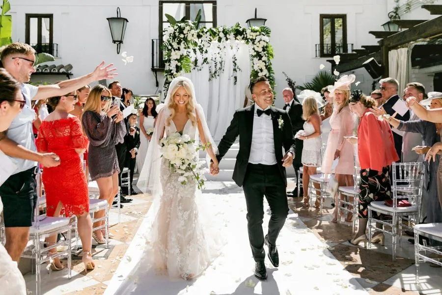 Newlyweds in a confetti shower leaving their ceremony, an Italy wedding planned by Swish Soirées