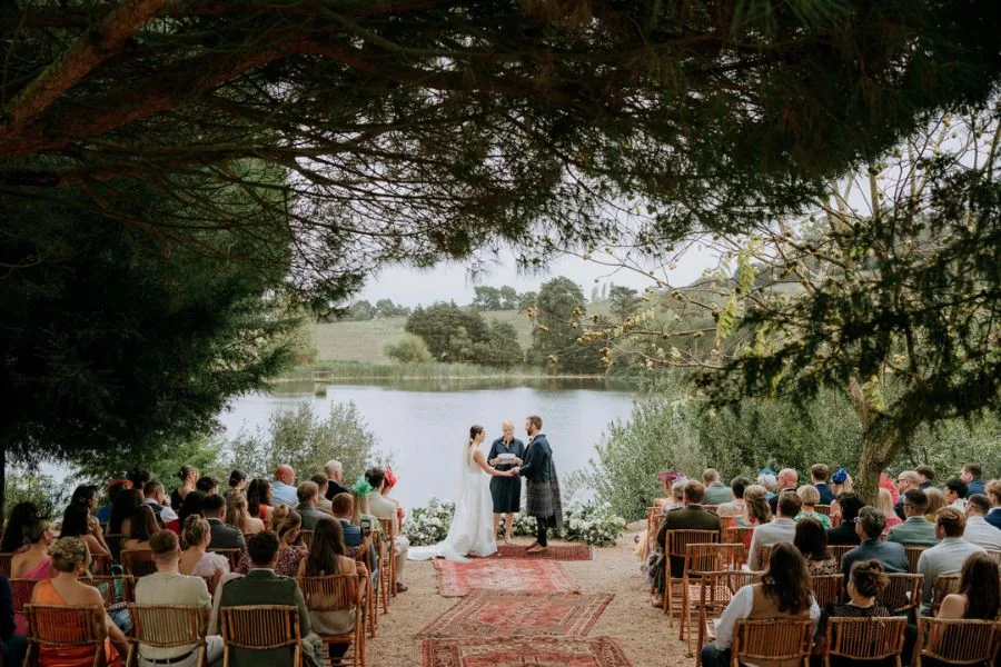 Open-air lakeside wedding ceremony with seated guests, a Marbella wedding planned by Swish Soirées